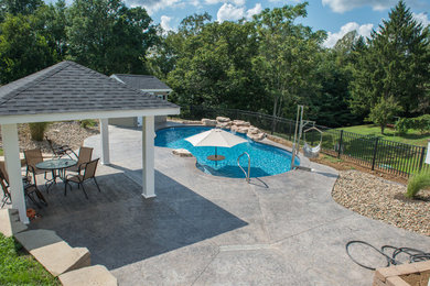 Mid-sized cottage chic backyard stamped concrete and custom-shaped natural pool fountain photo in Other