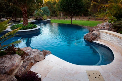 Großer Schwimmteich hinter dem Haus in Nierenform mit Wasserspiel und Natursteinplatten in Perth