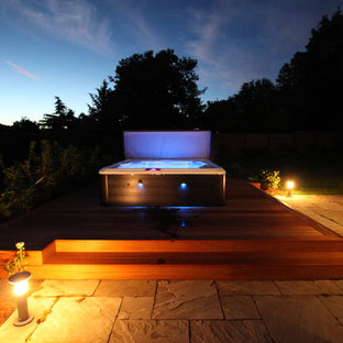 Idee per una piscina minimalista dietro casa con una vasca idromassaggio e pedane