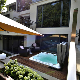 Esempio di una piscina minimalista dietro casa con una vasca idromassaggio e pedane