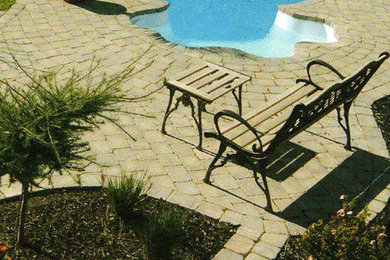Modelo de piscina a medida en patio trasero con adoquines de piedra natural