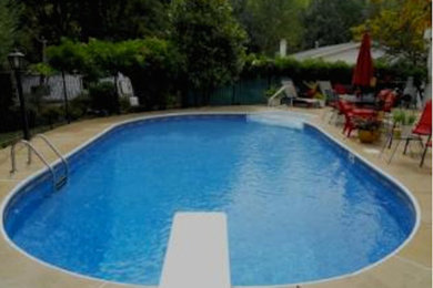 Example of a small classic backyard stamped concrete and round pool design in St Louis