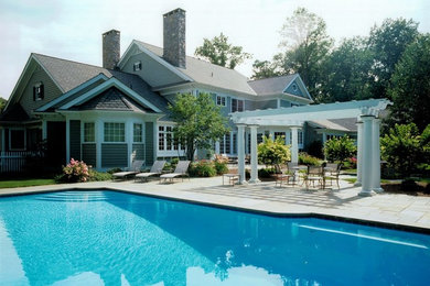 Pool - large traditional backyard concrete paver and rectangular lap pool idea in New York
