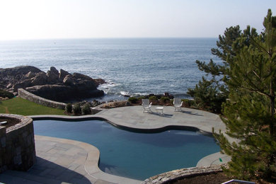 Diseño de piscina elevada contemporánea grande a medida en patio trasero con losas de hormigón