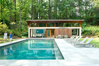 Modelo de casa de la piscina y piscina natural minimalista grande rectangular en patio trasero con adoquines de piedra natural