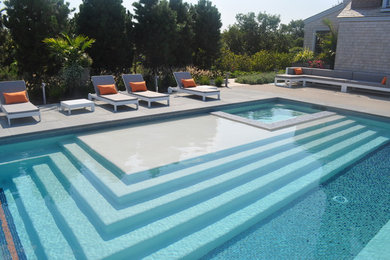 Ejemplo de piscina alargada actual extra grande rectangular con adoquines de piedra natural
