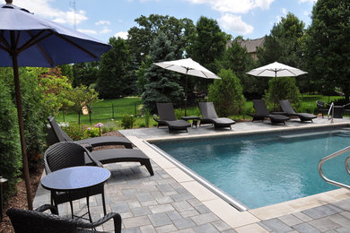 Pool - large contemporary backyard brick and rectangular lap pool idea in Chicago