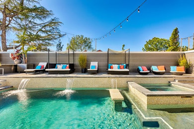 Foto de piscinas y jacuzzis alargados actuales grandes en forma de L en patio trasero con losas de hormigón