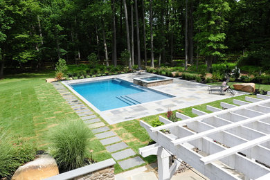 Imagen de piscinas y jacuzzis alargados clásicos grandes rectangulares en patio trasero con adoquines de piedra natural