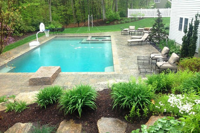 This is an example of a medium sized back custom shaped lengths hot tub in Boston with stamped concrete.