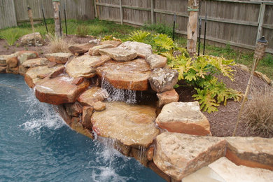 Mountain style stamped concrete and custom-shaped natural pool fountain photo in Houston