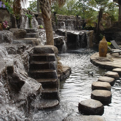 Example of a large mountain style backyard stone and custom-shaped natural pool fountain design in Seattle