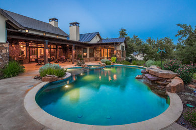 Example of a mountain style backyard concrete and kidney-shaped pool design in Austin
