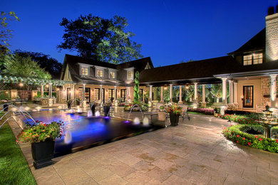 Huge elegant backyard stone and rectangular lap pool house photo in Chicago