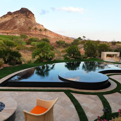 Hot tub - contemporary backyard stone and custom-shaped infinity hot tub idea in Las Vegas