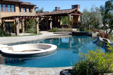 Inspiration for a large mediterranean backyard custom-shaped pool remodel in Los Angeles