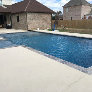 Idee per una grande piscina naturale contemporanea rettangolare dietro casa con fontane e pedane