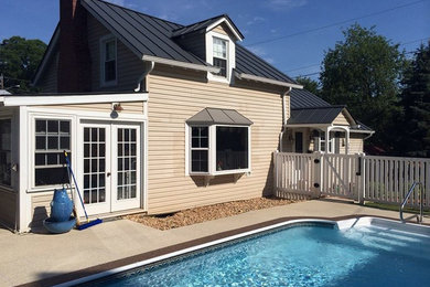 Foto de piscina alargada de tamaño medio rectangular en patio trasero con adoquines de hormigón