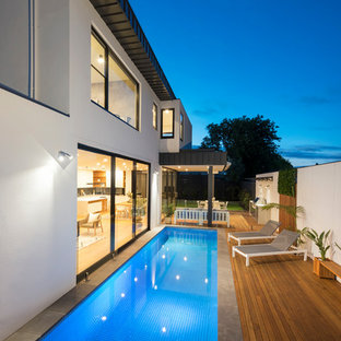 Contemporary side yard rectangular lap pool in Melbourne with tile.