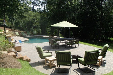 Modelo de piscina tradicional de tamaño medio a medida en patio trasero con adoquines de piedra natural