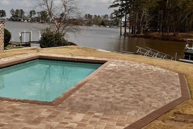 Example of a mid-sized classic backyard concrete paver and rectangular natural pool design in Other