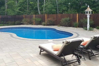 Mid-sized minimalist backyard concrete paver and custom-shaped natural pool photo in Boston