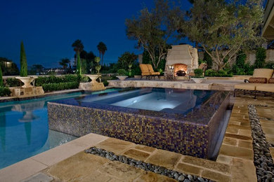 Inspiration for a large contemporary backyard stone and rectangular lap hot tub remodel in Orange County