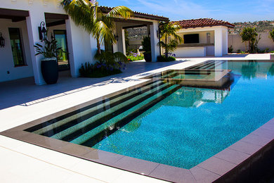Hot tub - mid-sized southwestern backyard concrete and rectangular infinity hot tub idea in Orange County