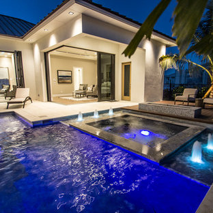 Large minimalist backyard custom-shaped and tile lap hot tub photo in Miami