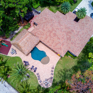 Ispirazione per una grande piscina naturale costiera personalizzata dietro casa con una vasca idromassaggio e pedane
