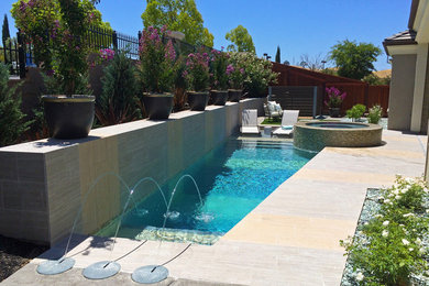Immagine di una piccola piscina design personalizzata dietro casa con una vasca idromassaggio e lastre di cemento