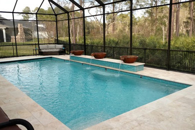 Diseño de piscina con fuente alargada clásica renovada de tamaño medio rectangular en patio trasero con adoquines de piedra natural