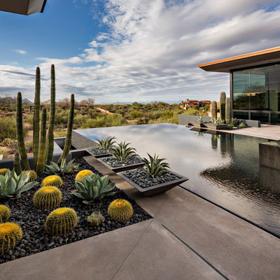 Inspiration for a large southwestern backyard concrete and rectangular infinity hot tub remodel in Phoenix
