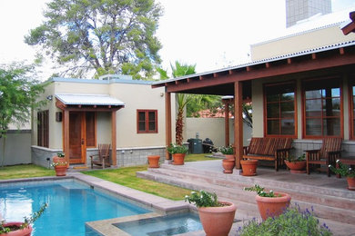 Modelo de casa de la piscina y piscina contemporánea de tamaño medio rectangular en patio trasero con suelo de hormigón estampado
