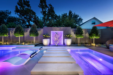 Foto de piscina minimalista grande rectangular en patio trasero con paisajismo de piscina y adoquines de piedra natural