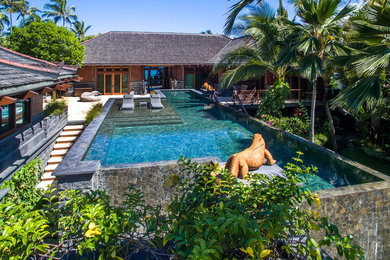 Ejemplo de piscina infinita tropical a medida en patio trasero