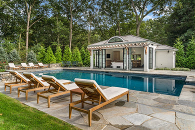 Elegant backyard stone and rectangular lap pool house photo in New York