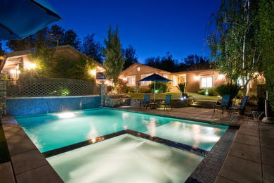 На фото: большой прямоугольный, спортивный бассейн на заднем дворе в стиле модернизм с джакузи и покрытием из бетонных плит