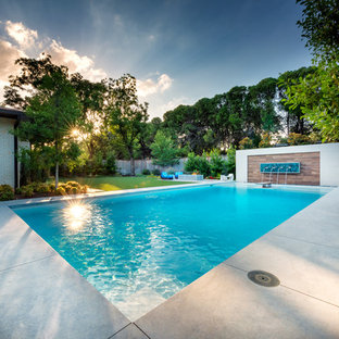 Esempio di una grande piscina moderna rettangolare dietro casa con pedane