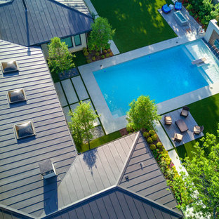 Esempio di una grande piscina moderna rettangolare dietro casa con pedane