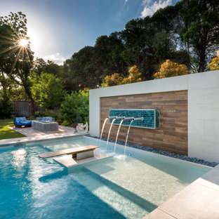Idee per una grande piscina minimalista rettangolare dietro casa con pedane
