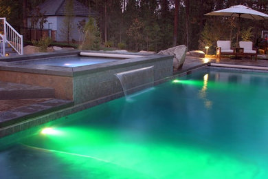 Mid-sized tuscan backyard stamped concrete and rectangular pool fountain photo in Seattle