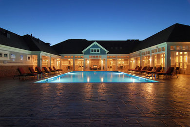 Imagen de piscina alargada de estilo americano grande rectangular en patio trasero con suelo de hormigón estampado