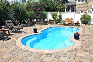 Inspiration for a timeless backyard concrete paver and kidney-shaped lap pool remodel in New York