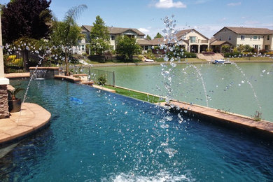 Großer Infinity-Pool hinter dem Haus in individueller Form mit Wasserspiel und Stempelbeton in Sacramento