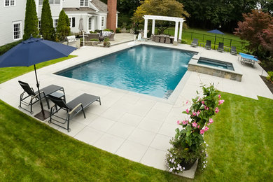 Photo of a large traditional back rectangular lengths hot tub in New York with concrete paving.
