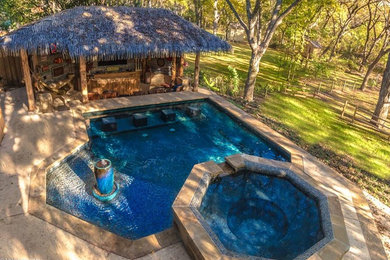 Foto de piscinas y jacuzzis alargados tropicales grandes a medida en patio trasero