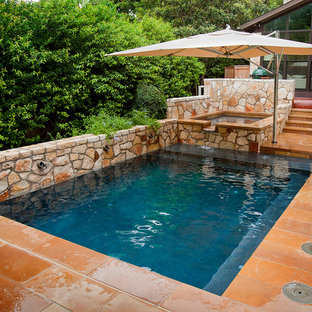 Inspiration for a small traditional backyard rectangular lap pool in Austin with natural stone pavers and a hot tub.
