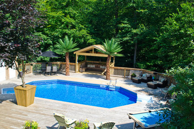 Пример оригинального дизайна: естественный бассейн среднего размера, произвольной формы на заднем дворе в классическом стиле с настилом