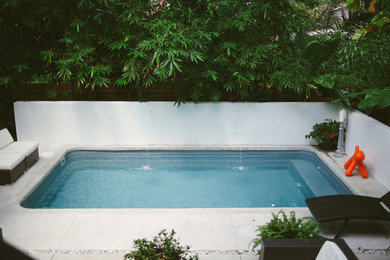 Foto de piscina con fuente natural contemporánea pequeña rectangular en patio trasero con losas de hormigón
